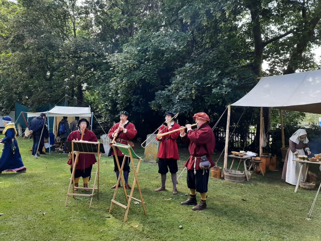 4 musicians dressed in tudor clothing playing period instruments