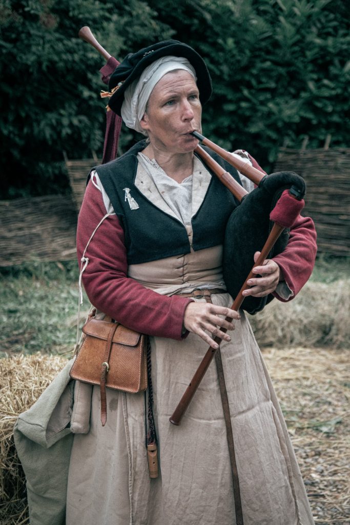 Emma in tudor period clothing playing the bagpipes